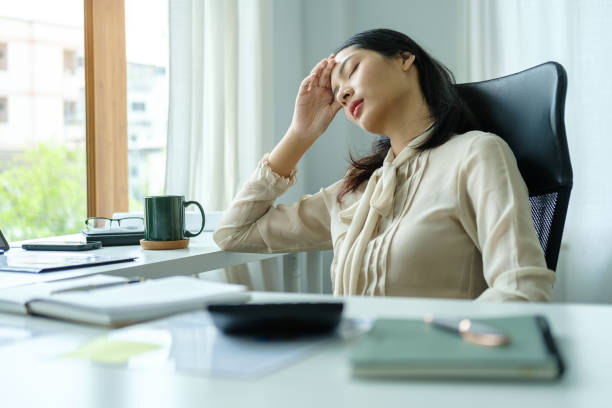 istock Exhausted asian female entrepreneur suffering from headache touching temples, stress at work or migraine. 1514149365