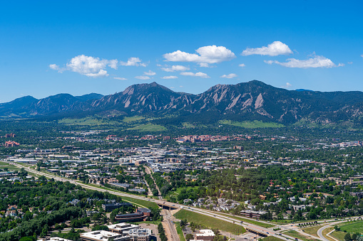 Aerial photo above Boulder Colorado on a clear day looking southwest towards University of Colorado and Flatiron Mountains and the city of Boulder with Highway 157 (Foothills Parkway) cutting across the foreground