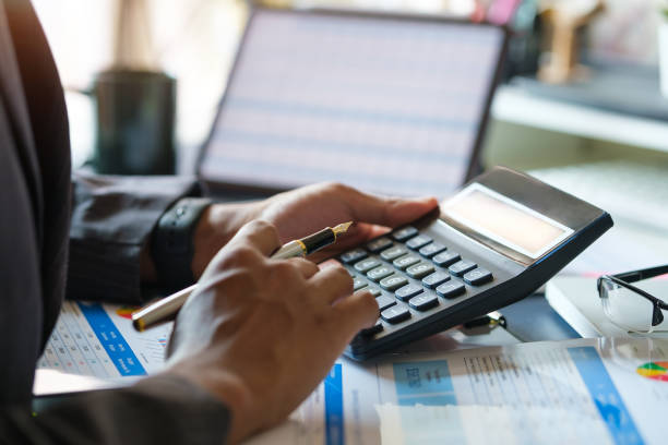 istock Focused accountant working using calculator for calculating finance taxing and statistics. 1514183996
