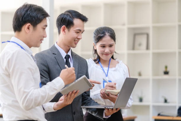 istock Happy friendly business team using laptop, working together on a new project at modern office. 1514188811