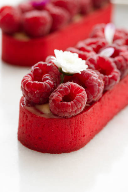 istock Raspberry tartlet decorated with flowers on a plate with antique spoons. 1514196921