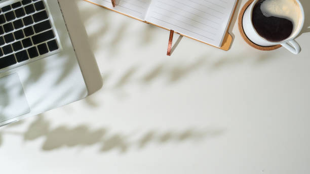 istock Cup of coffee, wireless keyboard and notebooks on wooden table. 1514204317