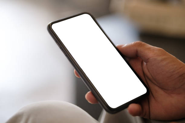 istock Closeup view of hands holding smartphone with blank screen and left side with empty space for your advertise or text message. 1514219337