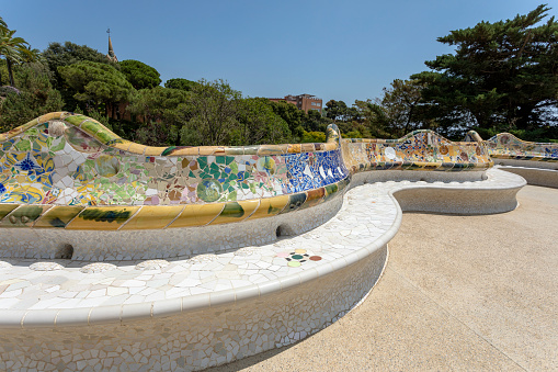 Barcelona, Spain - June 24, 2023: Famous Gaudi`s masterpiece, serpent bench made of mosaic tiles in Park Guell in Barcelona