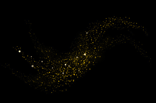 Abstract defocused lights and bokeh on dark background. Gold sparkles and glitter on black background