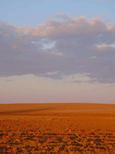 istock Cloudy evening sky over an empty agricultural field. Bright sunset landscape. 1514243430