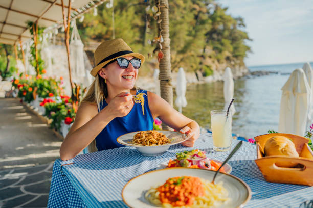 istock Woman eating pasta in a seaside restaurant 1514262737