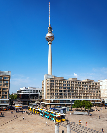 Iconic Alexanderplatz subway station: bustling hub, vibrant streets, modern urban atmosphere, with TV Tower and yellow tram.