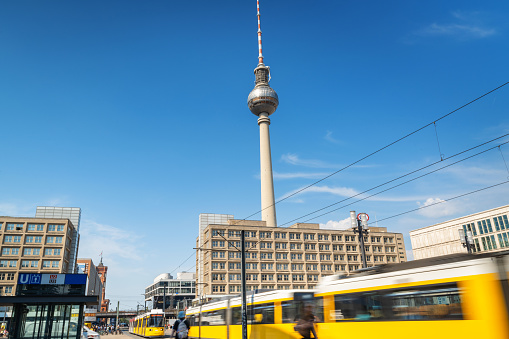 Iconic Alexanderplatz subway station: bustling hub, vibrant streets, modern urban atmosphere, with TV Tower and yellow tram.