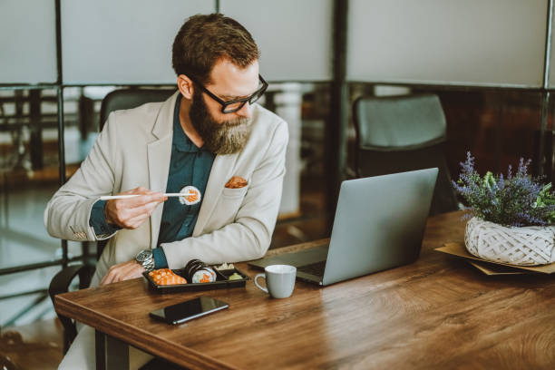 istock Businessman eating sushi in the office 1514280751