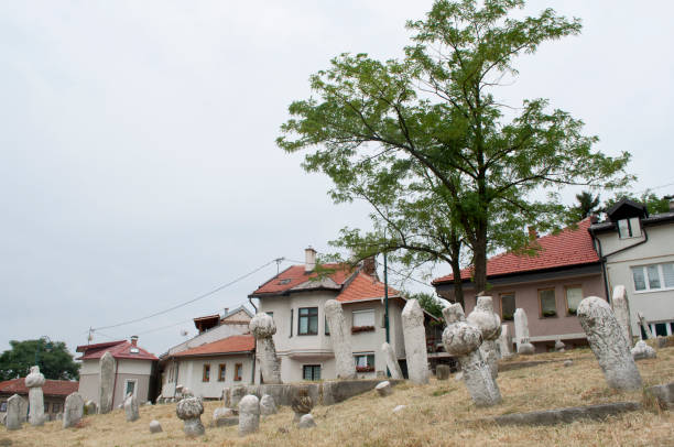 Houses and Ancient Stone Graves in a Sarajevo Cemetery Houses and Ancient Stone Graves in a Sarajevo Cemetery Post Balkan War. Cityscape in Bosnia Herzegovina ethnic cleansing stock pictures, royalty-free photos & images
