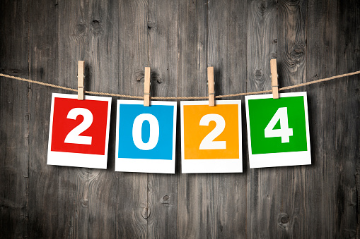 New year 2024 print photos hanging over wooden background
