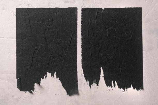 Scraps of black paper on a bulletin board.