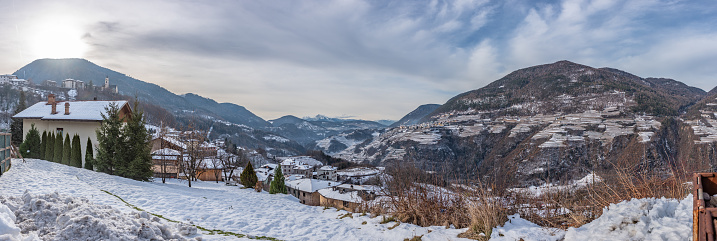 Wallpaper Panoramic View Of Village In The Mountains In The North Of Italy In Winter Covered By Snow At Sunrise On Blurred Background