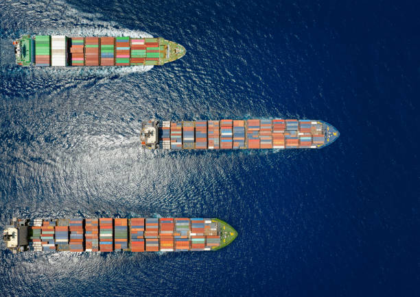 istock High aerial top down view of  three container cargo ships in motion over open ocean 1514375277