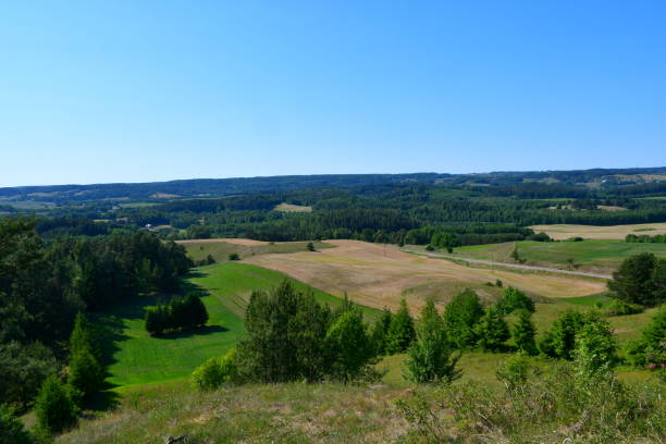 istock A view from a tall hill covered with trees, forests, moors, fields, and other flora with the view of a vast round and clean lake or river in the distance seen on a sunny summer day in Poland 1514402648