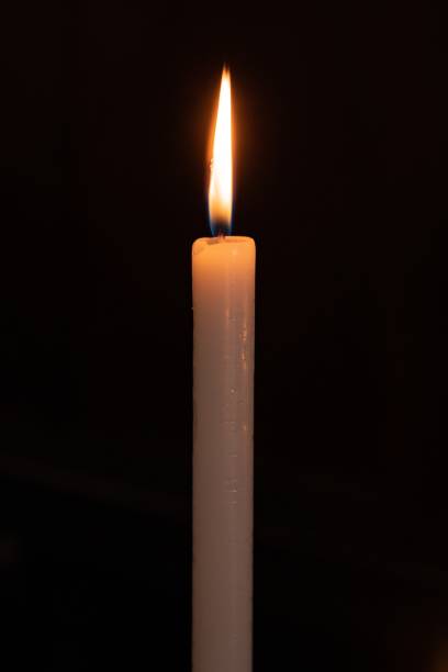 istock Single burning candle in the foreground 1514417476