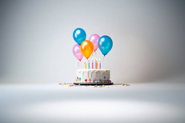 istock white Birthday cake with colorful balloons over white, 1514453519