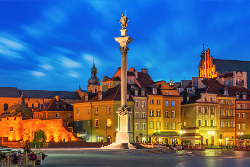 Castle Square with Royal Castle, colorful houses and Sigismund Column in Old town at night, Warsaw, Poland.