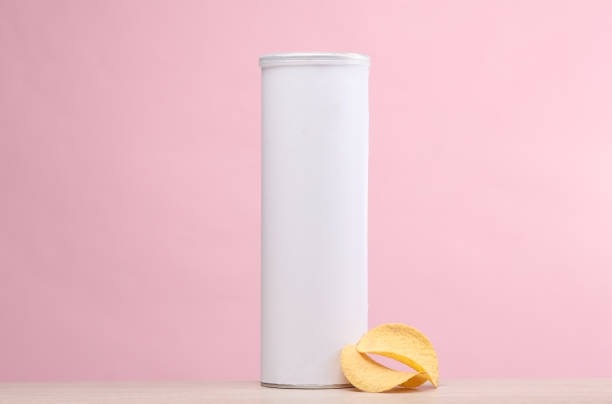 Potato chips tin with white label mockup on table, pink background. Template for design