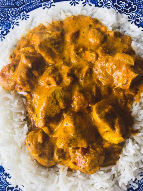 istock Chicken tikka masala with boiled basmati rice on a blue plate 1514583648