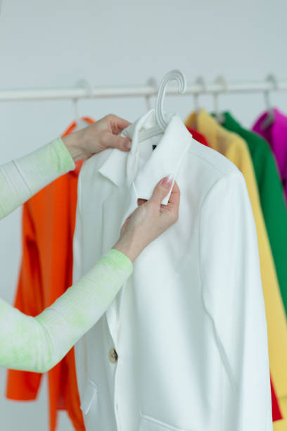 istock A woman's hand chooses clothes on a hanger on a white background 1514587402