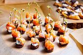Canapes with salmon, cheese and rye bread on skewers.