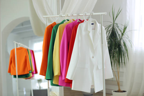 istock Multi-colored bright jackets on a hanger against the background of the room. 1514634209
