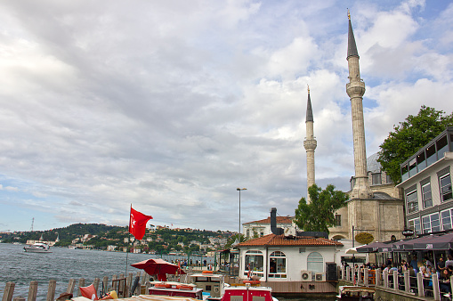 Istanbul, Turkey - June 29, 2023: People on beylerbeyi pier near the Beylerbeyi Mosque or Beylerbeyi Camii also known as the Hamid i-Evvel Mosque is a mosque located in the Beylerbeyi neighbourhood in Istanbul, Turkey. It was first built in 1777–1778 by the Ottoman sultan Abdülhamid I, but was later modified by Mahmud II in 1820–1821.