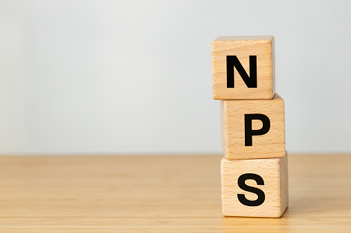 NPS acronym written on wooden blocks, Net Promoter Score, Company customer loyalty assessment tool, Customer satisfaction correlated with revenue growth, Business concept, copy space
