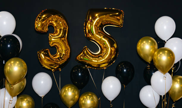 istock Celebrating 35 Years with Gold and Black Balloons. 1514654843