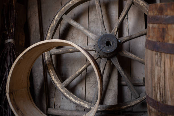 istock Old authentic wooden wheel from a cart in a rustic barn. 1514668568