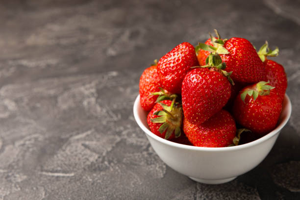 istock Fresh ripe juicy strawberries on a black cement table. Summer background composition with strawberries. Fruit concept.Vitamins.Eco berries. Copy space 1514669660