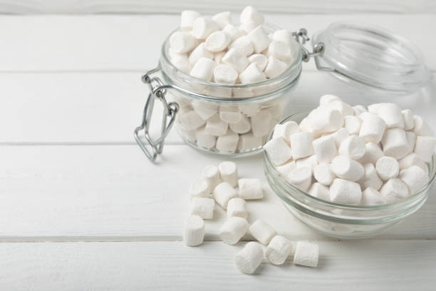 istock Loose white marshmallows on white texture wood.Sweets and snacks for a snack.Chewy candy close-up.Copy space.Place for text. 1514684079
