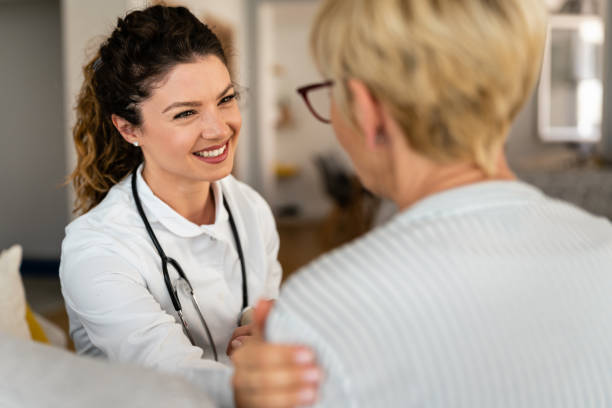 Support, trust and empathy during counseling or therapy with nurse at home Happy smiling female doctor at home visit talking to unrecognizable senior blonde woman. Support, trust and empathy during counseling or therapy with nurse at home. medical occupation stock pictures, royalty-free photos & images