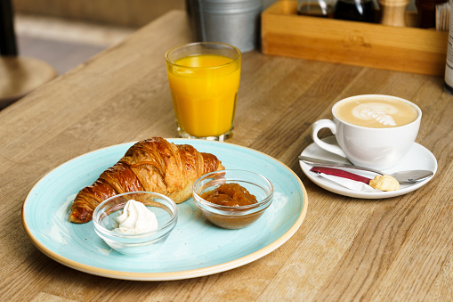 Healthy breakfast served with scrambled eggs, cereals with fruits, bread and honey.