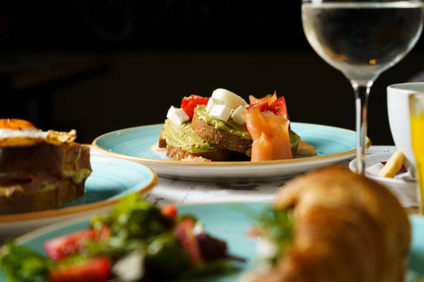 istock Brunch table with Avocado toast with guacamole, soft boiled egg, salmon, cream cheese and tomatoes on a plate 1514712290