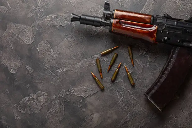 Photo of Bullets and ammo magazine with kolashnikov assault rifle on  texture marble.Composition with place for text.Rifle and carbine cartridges on wooden background.Military concept.Copy space