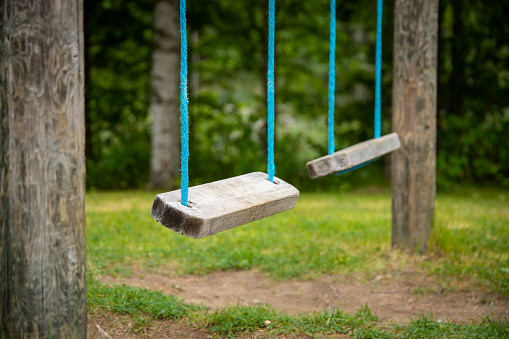 empty wooden swings with blurry background