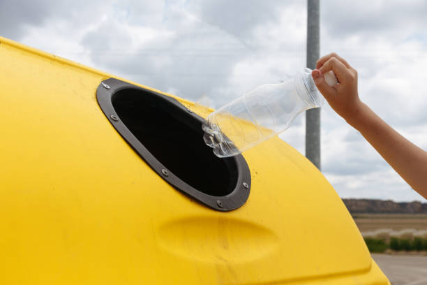 istock Close-up hand throwing out a plastic bottle in a trash can 1514757157