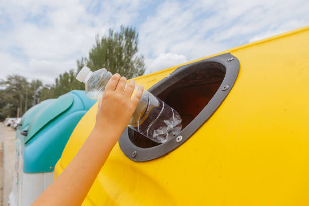 istock Close-up hand throwing out a plastic bottle in a trash can 1514757161