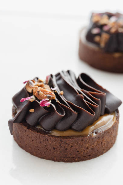 istock Chocolate tartlets decorated with dark chocolate ganache on a white background. 1514757697