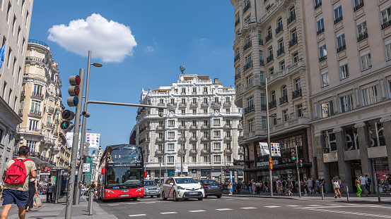Madrid, Spain - June 22, 2023: Hot afternoon to ride a double-decker tourist bus, along the Gran Vía, in Madrid.
