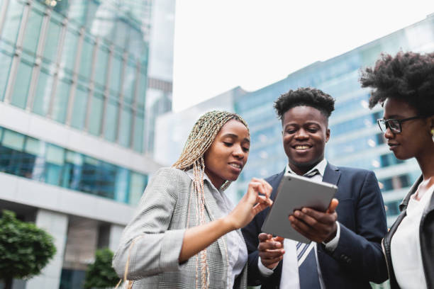 istock Young adult black colleagues discussing new project using digital tablet 1514765569
