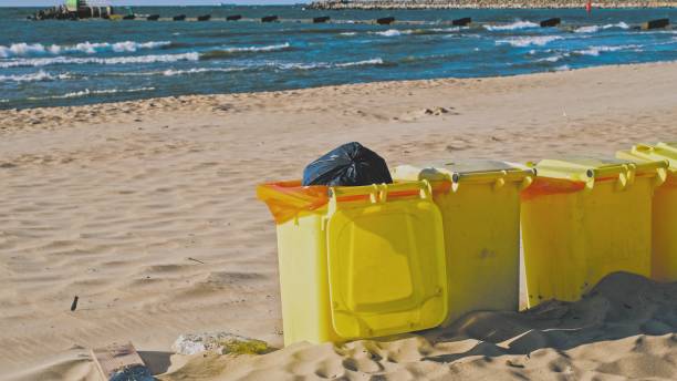 istock Row of Plastic Garbage Bins Deployed on Seashore Beach Sand 1514793852