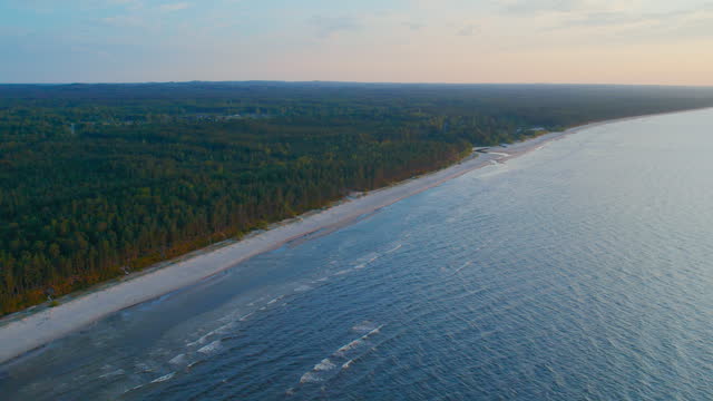 Embark on an aerial journey above Jurmala and marvel at the intertwining dance of sea waves and the pristine golden sand, all captured by a drone