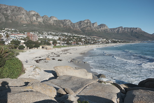 Cape Town Camps Bay. Beautiful Beach at Camps Bay. Scenic view in late afternoon late close to the setting  sun. Camps Bay is a famous and beautiful suburb of the city of Cape Town with white sandy beaches, luxury villas and hotels underneath the Table Mountain. Cape Town, South Africa, Africa