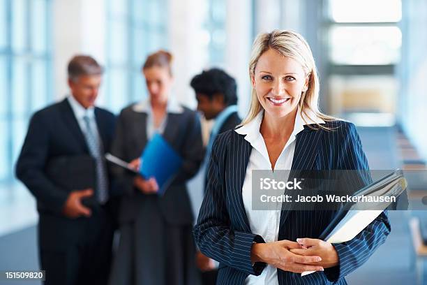 Happy Businesswoman With Colleagues In The Background Stock Photo - Download Image Now