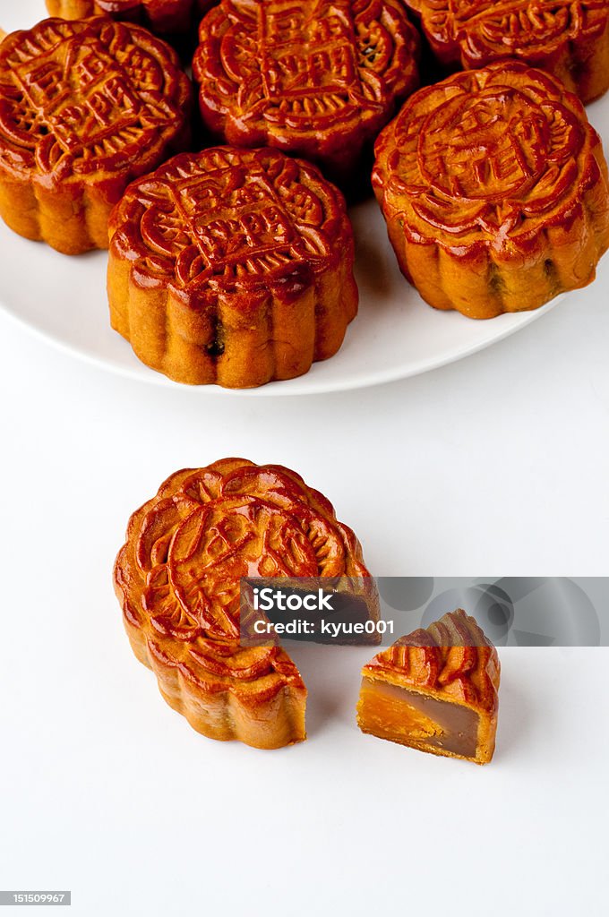 Mooncake with a section removed A Chinese moon cake with a section removed. Several moon cakes in the background. Cake Stock Photo