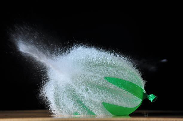 Bursting green water balloon stock photo